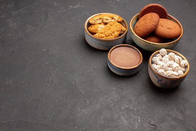 Vue de face de délicieux biscuits au sucre avec des bonbons sur fond sombre biscuit au sucre biscuit sucré