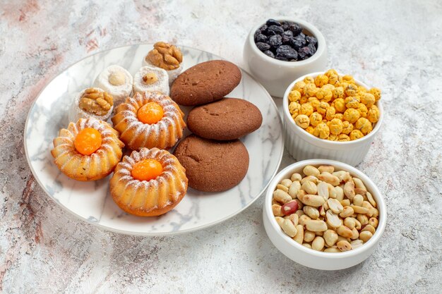 Vue De Face De Délicieux Biscuits Avec Des Bonbons Et Des Noix Sur Un Espace Blanc