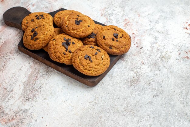 Vue de face de délicieux biscuits de sable bonbons parfaits pour une tasse de thé sur une surface blanche