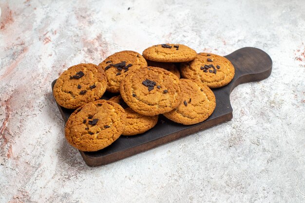 Vue de face de délicieux biscuits de sable bonbons parfaits pour une tasse de thé sur une surface blanche