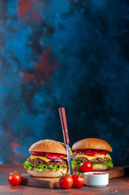 Photo gratuite vue de face délicieux cheeseburger à la viande sur une planche à découper fond bleu restauration rapide repas collation frites dîner plat sandwich
