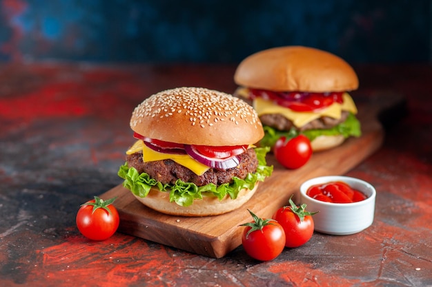 Photo gratuite vue de face délicieux cheeseburger à la viande sur une planche à découper sombre
