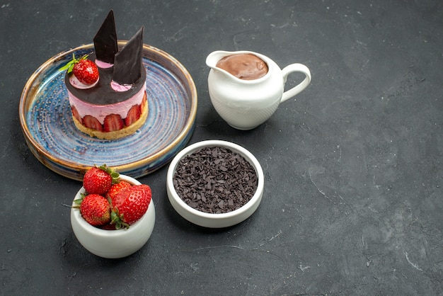 Photo gratuite vue de face délicieux cheesecake à la fraise et au chocolat sur des bols en assiette avec des fraises au chocolat