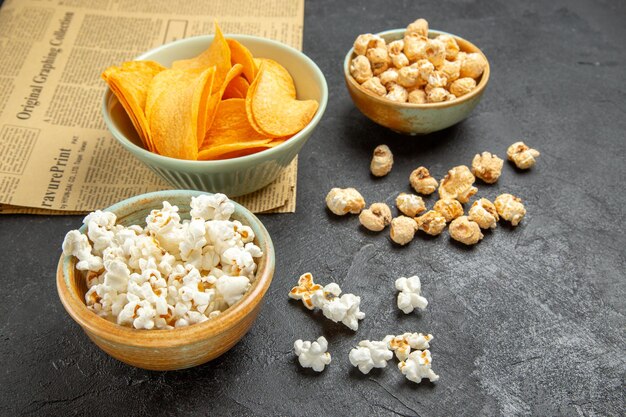 Vue de face de délicieux cips au fromage avec différentes collations sur fond sombre