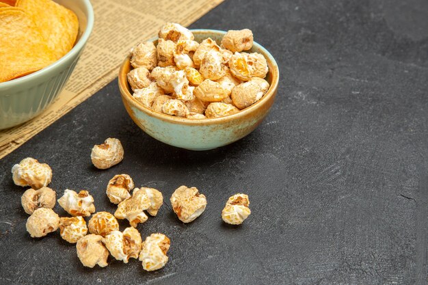 Vue de face de délicieux cips au fromage avec différentes collations sur fond sombre