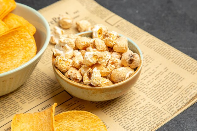 Vue de face de délicieux cips au fromage avec différentes collations pour l'heure du film sur fond sombre