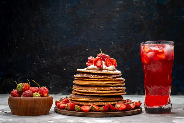 Une vue de face délicieux crêpes rondes avec crème et fraises rouges cocktail glacé sur le gâteau de bureau léger