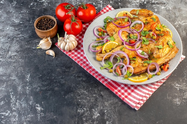 Vue de face d'un délicieux dîner plat de poulet frit avec diverses épices et aliments tomates avec tiges poivre oignons ails sur le côté gauche sur fond de couleur sombre