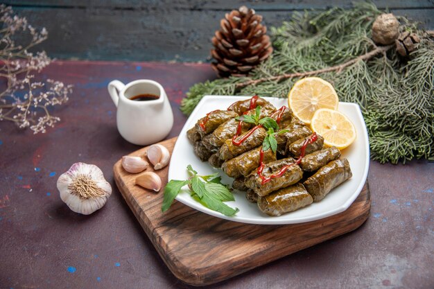 Vue de face délicieux dolma de feuilles avec des tranches de citron sur l'espace sombre