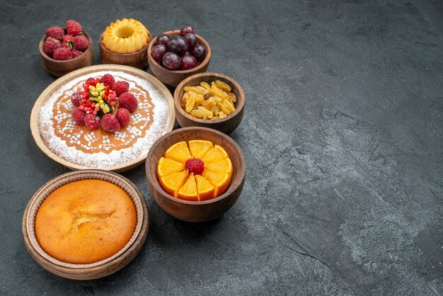 Vue de face délicieux gâteau aux framboises avec fruits et raisins secs sur fond gris berry tarte sucrée gâteau aux fruits biscuit biscuit