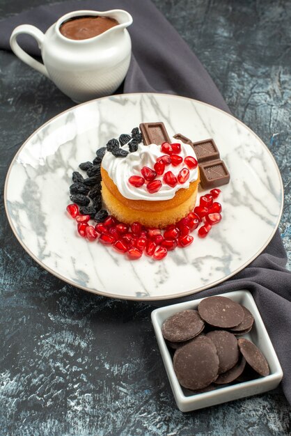 Vue de face délicieux gâteau crémeux au chocolat et aux raisins secs sur fond clair-foncé biscuit sucré dessert biscuit sucre