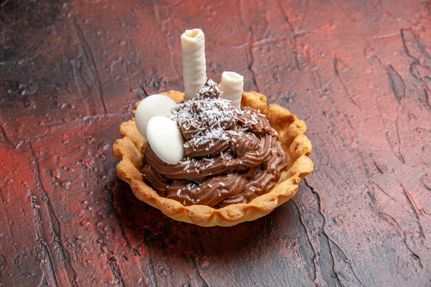 Vue de face délicieux gâteau crémeux sur le fond sombre