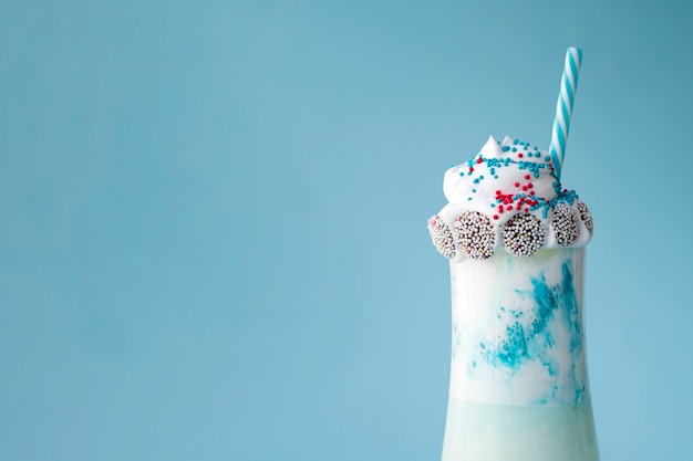 Vue de face de délicieux milkshake sur fond bleu