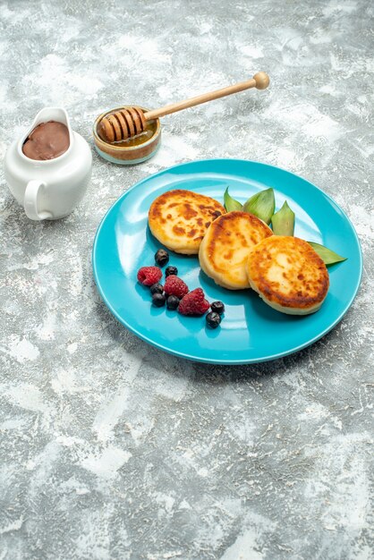 Vue de face de délicieux muffins aux baies sur une table lumineuse