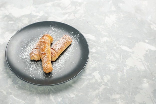 Vue de face de délicieux petits pains sucrés avec du sucre en poudre