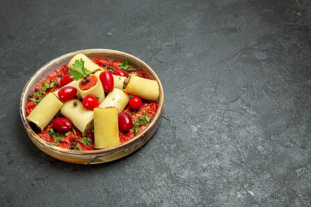 Vue de face de délicieux repas de pâtes italiennes cuites avec de la viande et de la sauce tomate sur le fond gris pâte pâtes viande sauce alimentaire