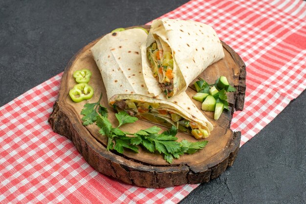 Vue de face délicieux sandwich à la salade shaurma en tranches avec des légumes verts sur une surface grise burger sandwich salade pita