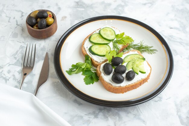 Vue de face de délicieux sandwichs aux olives et aux concombres à l'intérieur de la plaque fond blanc santé toast repas burger nourriture pain déjeuner horizontal