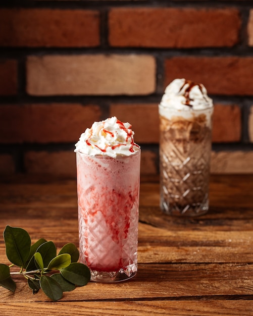 Une vue de face dessert à la crème aux fraises et au chocolat sur le bureau en bois de fruits de crème glacée dessert