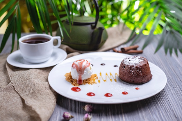 Vue de face dessert fondant au chocolat avec de la crème glacée et une tasse de thé