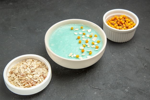 Vue de face dessert glacé bleu avec du muesli cru sur le petit-déjeuner glacé crème au sol