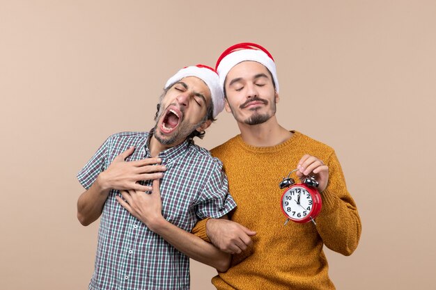 Vue de face deux hommes endormis un bâillement en se tenant debout sur fond isolé beige