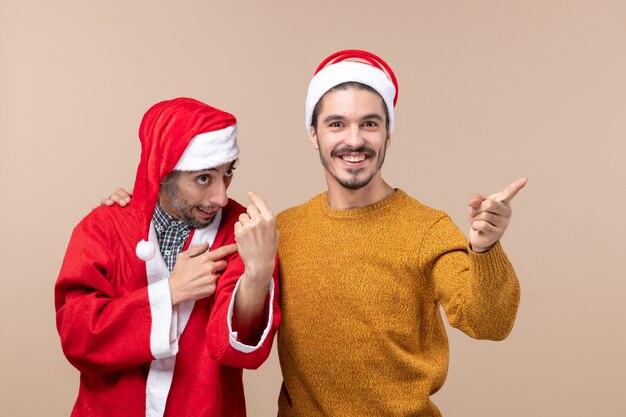 Vue de face deux hommes l'un regardant la caméra et l'autre vers la droite sur fond isolé beige