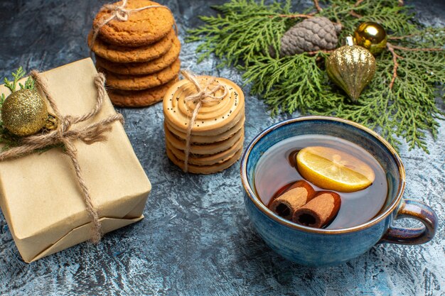 Vue de face différents biscuits sucrés avec tasse de thé sur fond clair