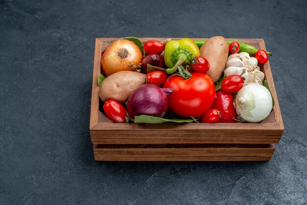 Vue de face différents légumes frais sur des légumes de table sombres salade fraîche mûre