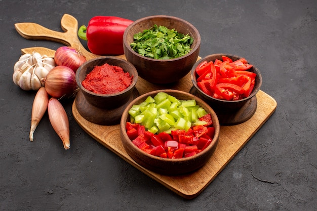 Vue de face différents légumes avec des verts sur fond gris repas salade santé mûr épicé