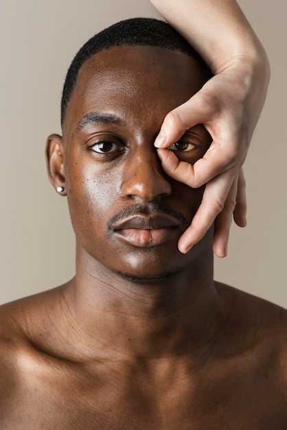 Photo gratuite vue de face du bel homme posant avec la main autour de ses yeux