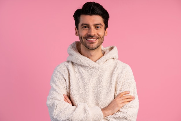 Vue de face du bel homme souriant avec les bras croisés