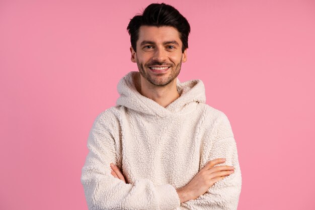 Vue de face du bel homme souriant avec les bras croisés