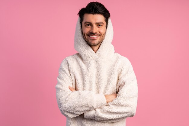 Vue de face du bel homme souriant avec les bras croisés