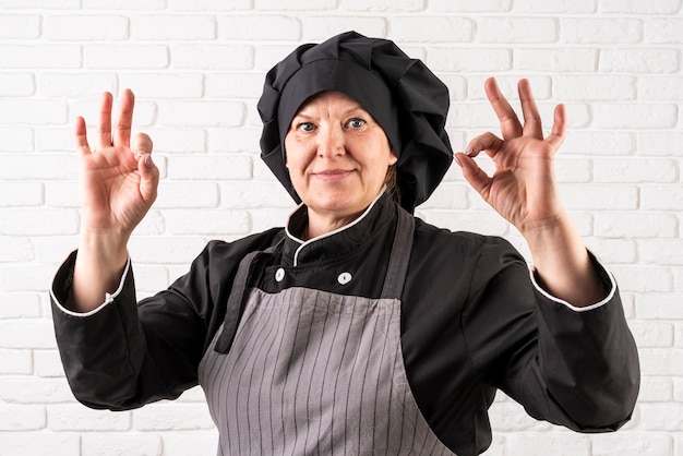 Vue de face du chef féminin faisant signe ok