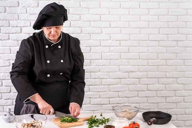 Vue de face du chef féminin hacher les verts