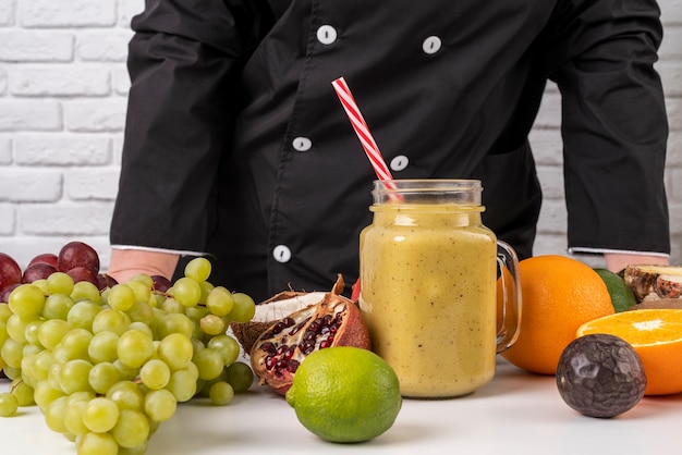 Photo gratuite vue de face du chef avec fruits et jus