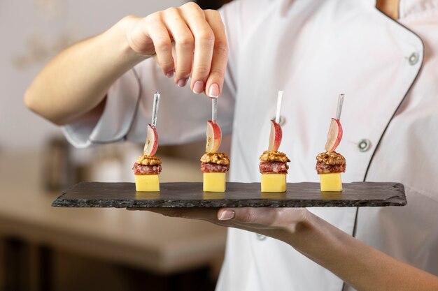 Vue de face du chef tenant une assiette de nourriture délicieuse