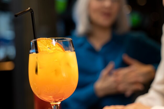 Vue de face du cocktail avec des amis seniors défocalisés se parlant