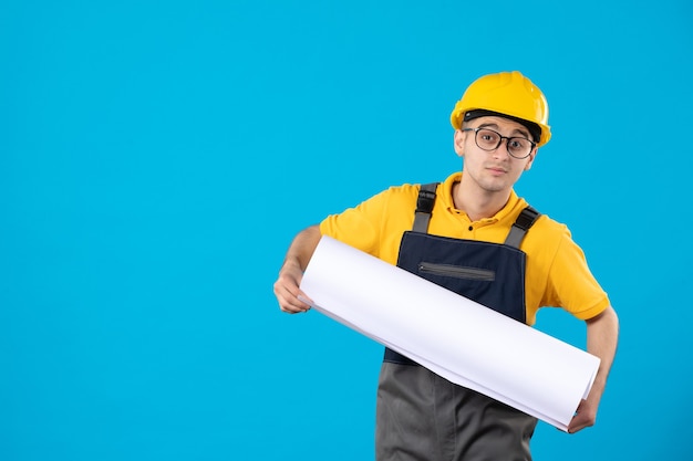 Vue de face du constructeur masculin en plan de lecture uniforme jaune sur bleu