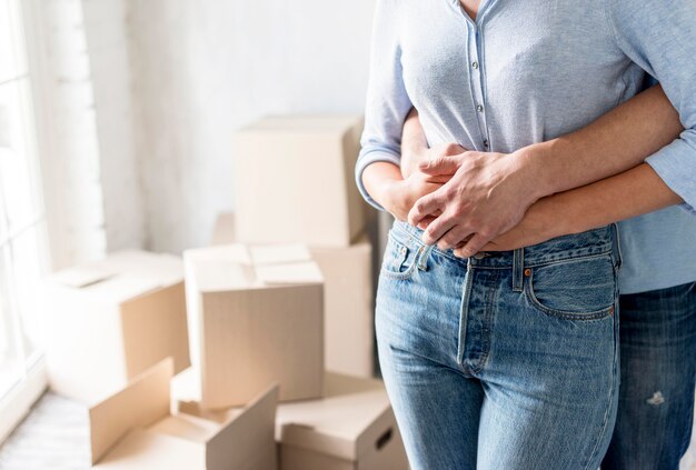 Vue de face du couple embrassé à la maison lors de l'emballage pour se déplacer