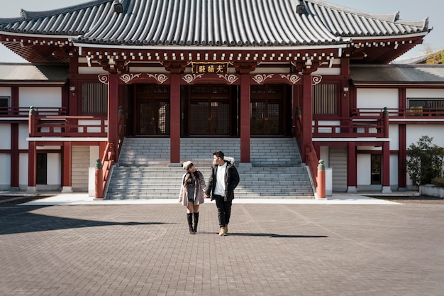 Vue de face du couple en face du bâtiment japonais