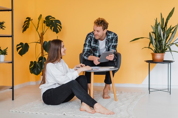 Vue de face du couple faisant des plans ensemble pour redécorer le ménage