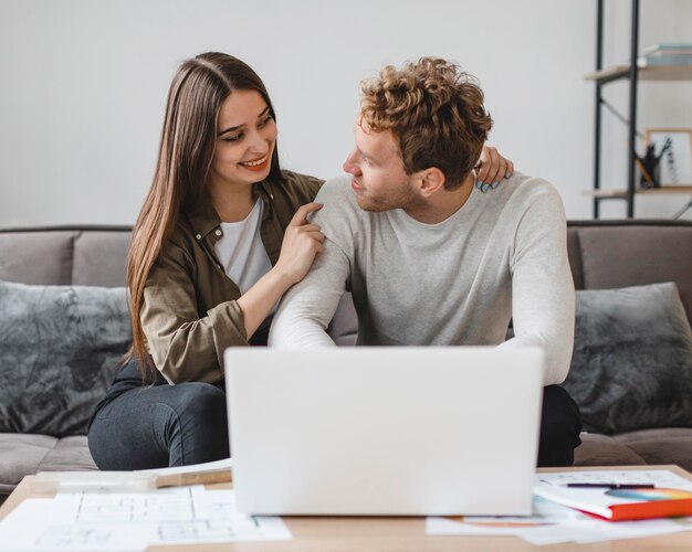 Vue de face du couple faisant des plans pour remodeler la maison ensemble