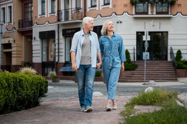 Vue de face du couple senior embrassé profitant de leur temps dans la ville