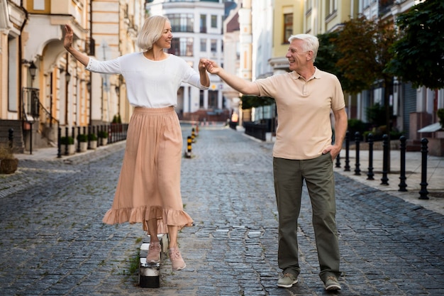 Vue de face du couple senior souriant bénéficiant d'une promenade à l'extérieur