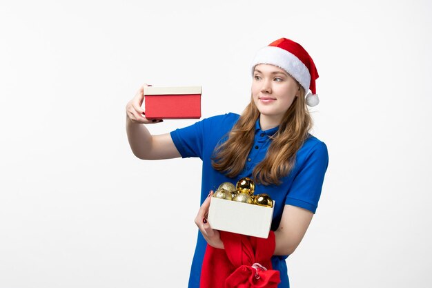 Vue de face du courrier féminin avec cadeau et jouets sur mur blanc