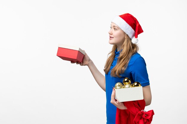 Vue de face du courrier féminin avec cadeau et jouets sur mur blanc