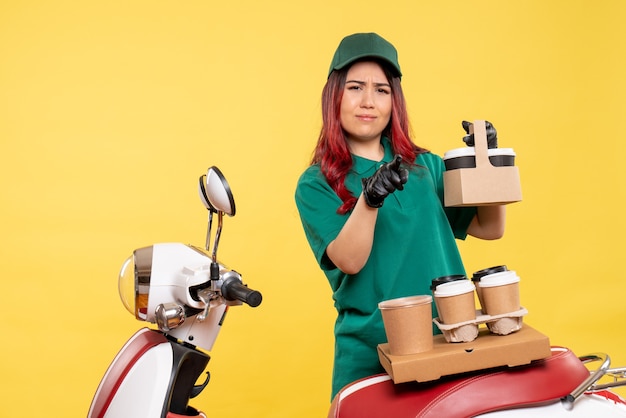 Vue de face du courrier féminin avec café sur mur jaune