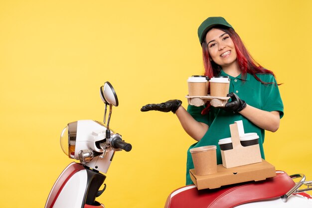 Vue de face du courrier féminin avec café sur mur jaune